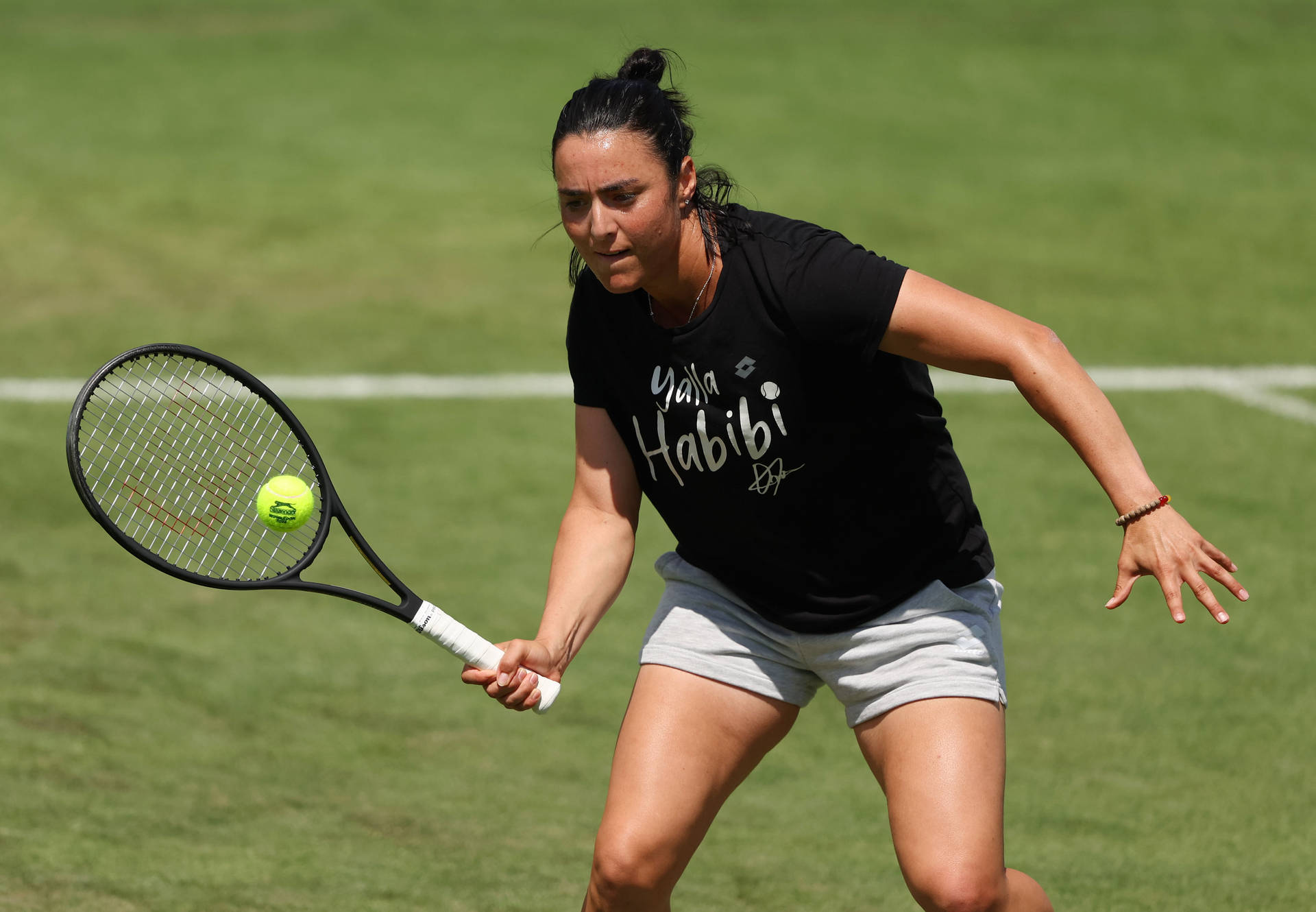 Caption: Ons Jabeur Proudly Displaying Her 'yalla Habibi' Sportswear T-shirt. Background