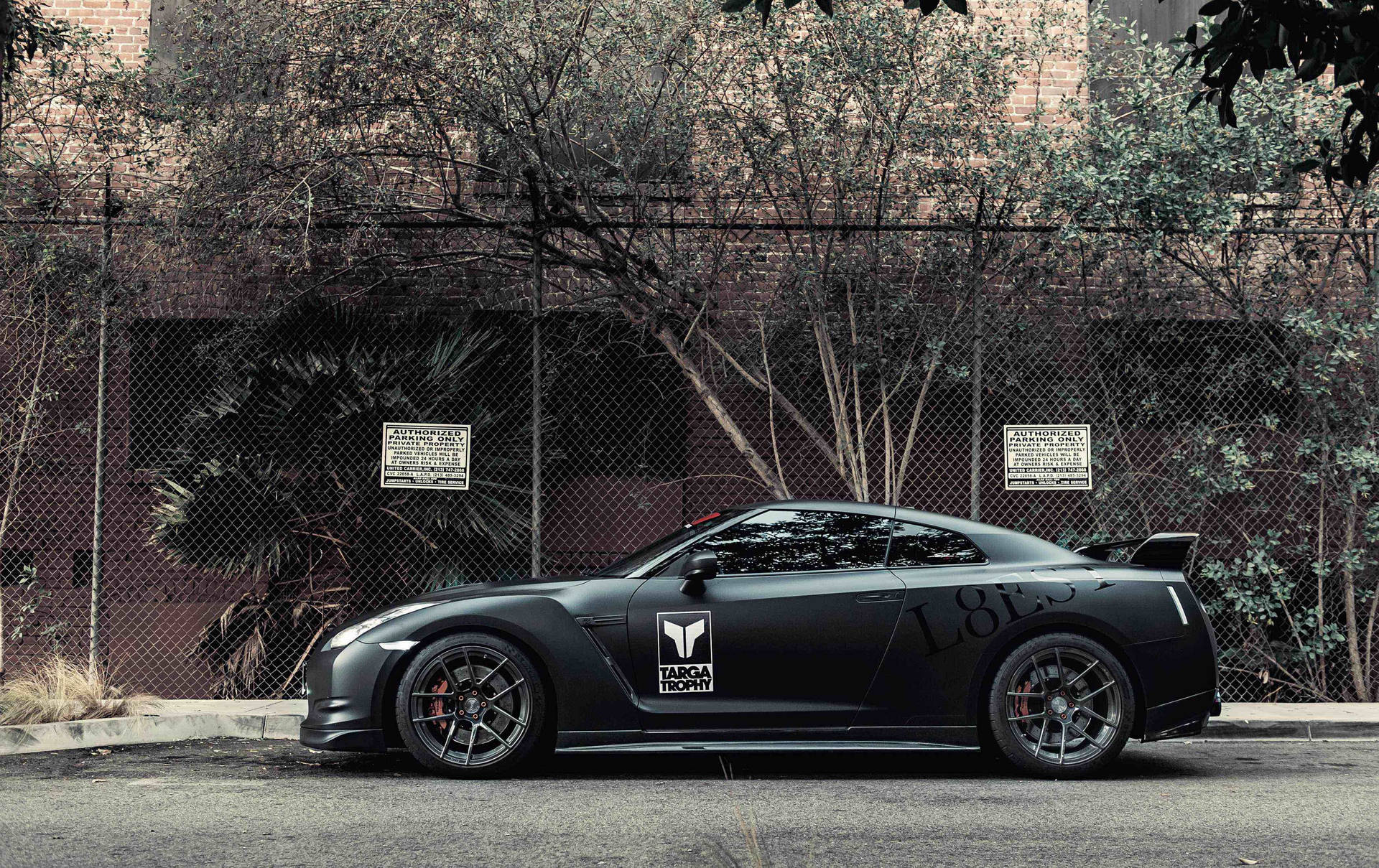 Caption: Powerful Nissan Skyline Gtr R35 Parked Behind Mesh Fencing. Background