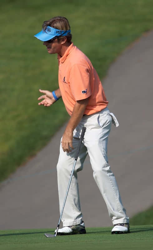 Caption: Professional Golfer Brett Quigley Focused On The Course Background
