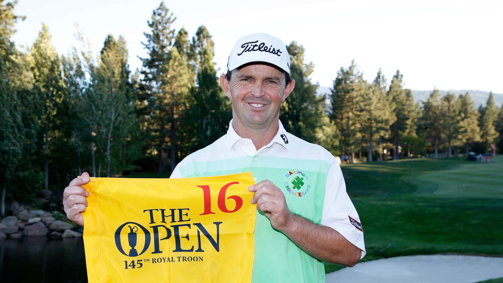 Caption: Professional Golfer Greg Chalmers Holding A Yellow Banner Background