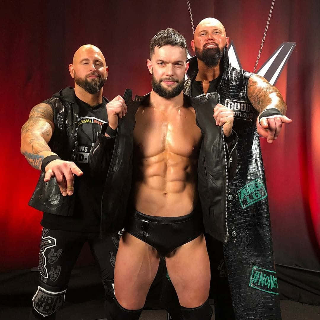 Caption: Professional Wrestler Karl Anderson Posing With Gallows Balor. Background
