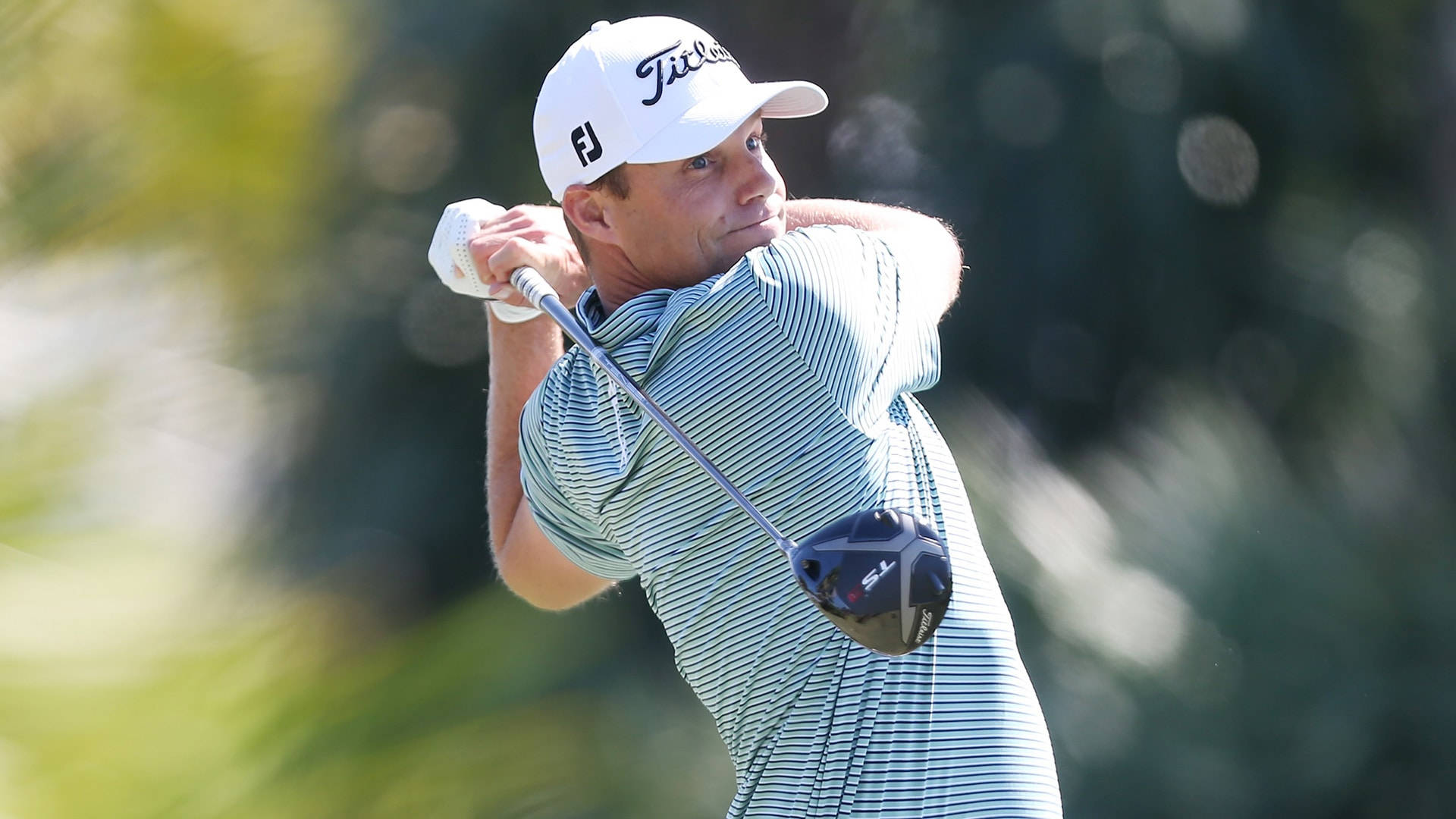 Caption: Prominent Golfer Nick Watney In Mid-swing On Green Background