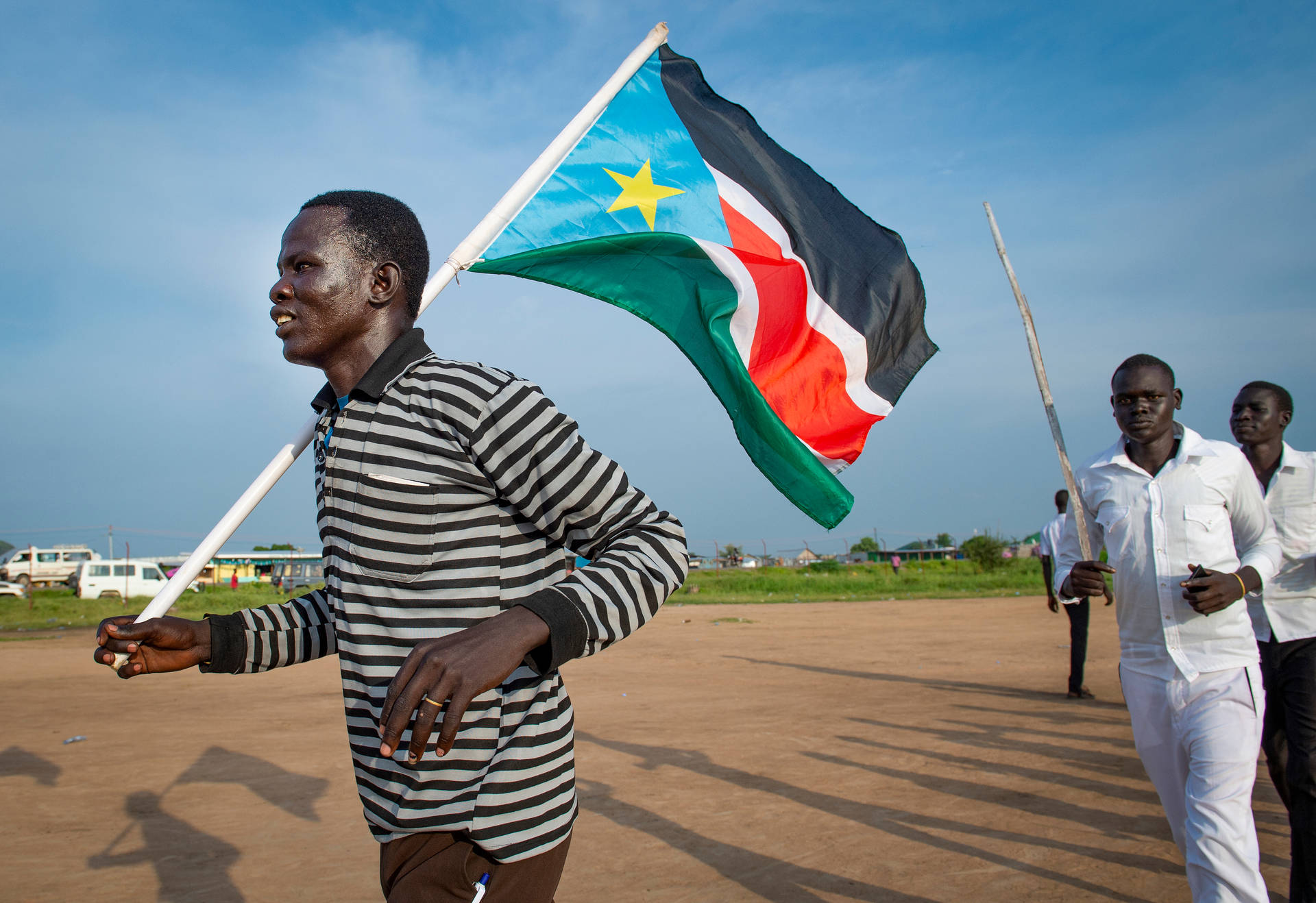 Caption: Proud South Sudan Man Holding National Flag Background