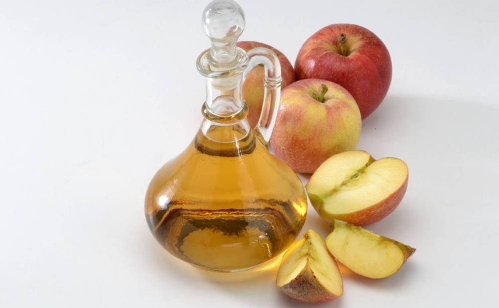 Caption: Pure Apple Cider Vinegar In A Glass Container Background