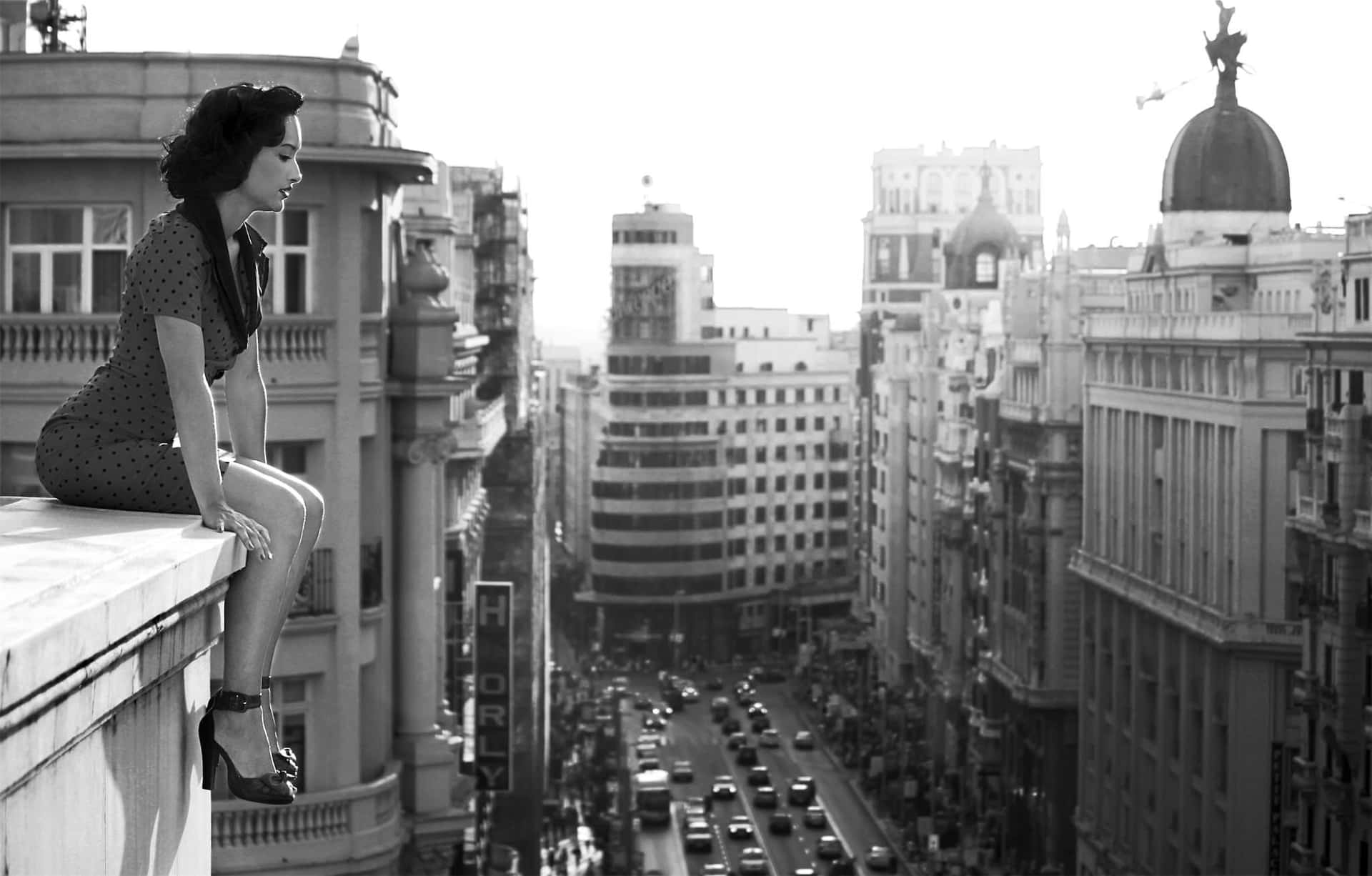 Caption: Reflective White Lady Overlooking The City From A Rooftop Background