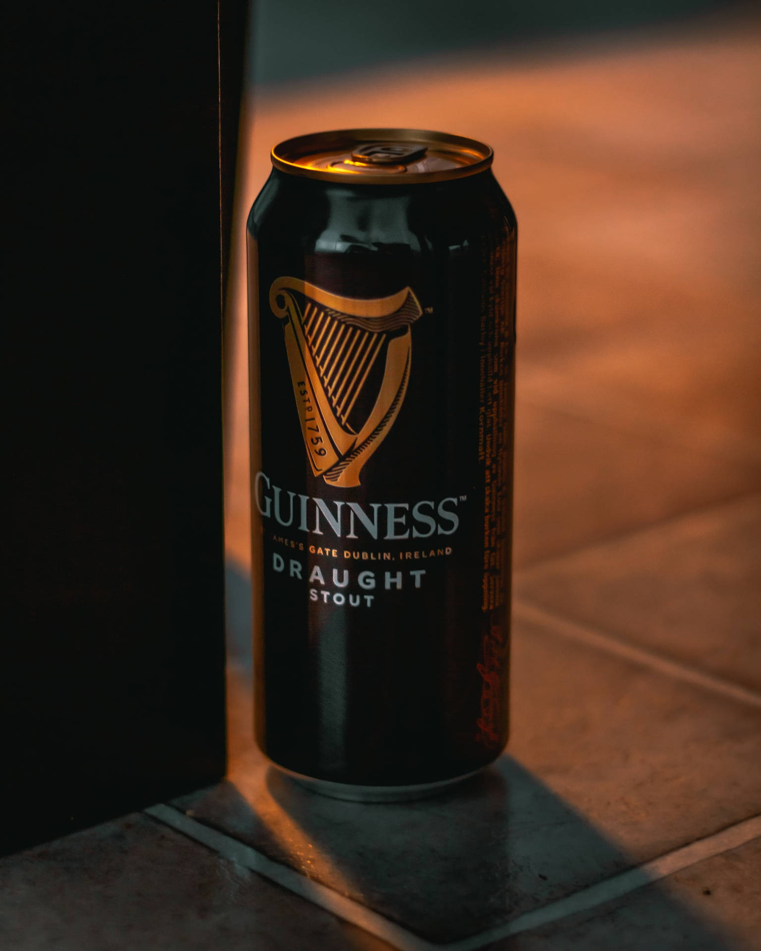 Caption: Refreshing Guinness Stout Can On A Cinematic Background Background