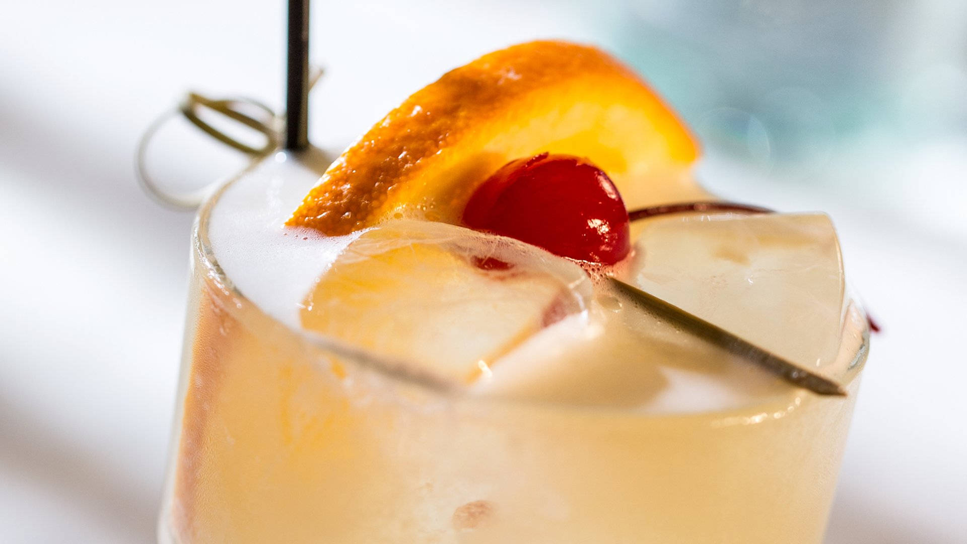 Caption: Refreshing Sour Club Beverage In A Brightly Lit Bar Background