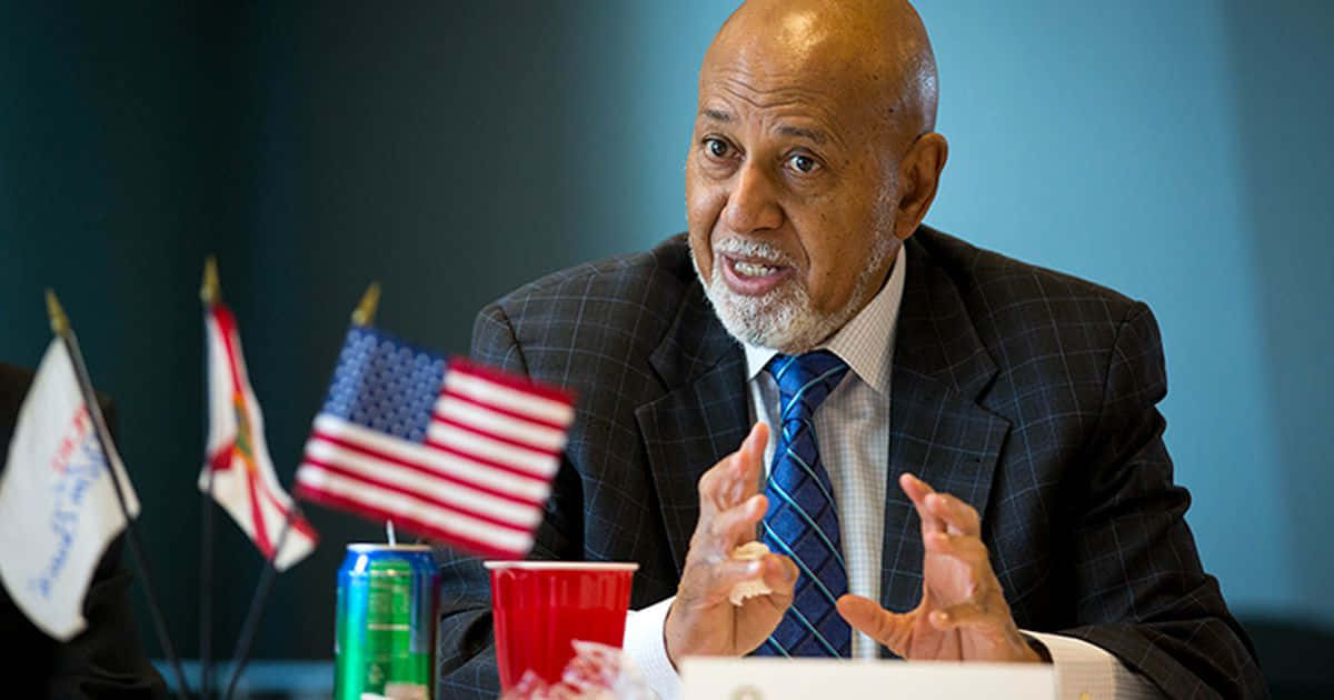 Caption: Renowned Congressman Alcee Hastings Flaunting A Blue Tie Background