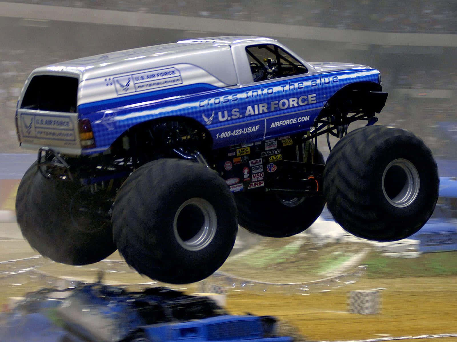 Caption: Roaring Power Unleashed – The Monster Truck Showdown Background