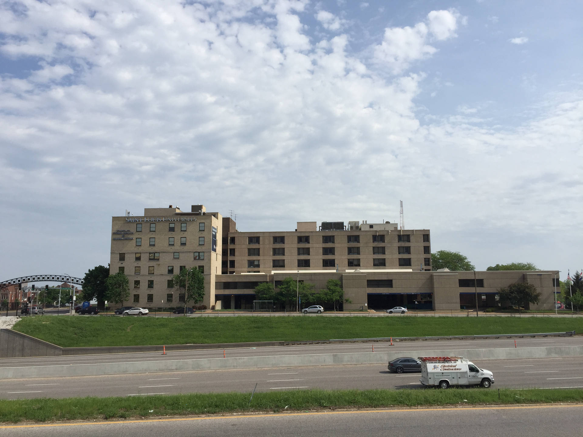 Caption: Saint Louis University Public Health Building Under Clear Blue Sky Background