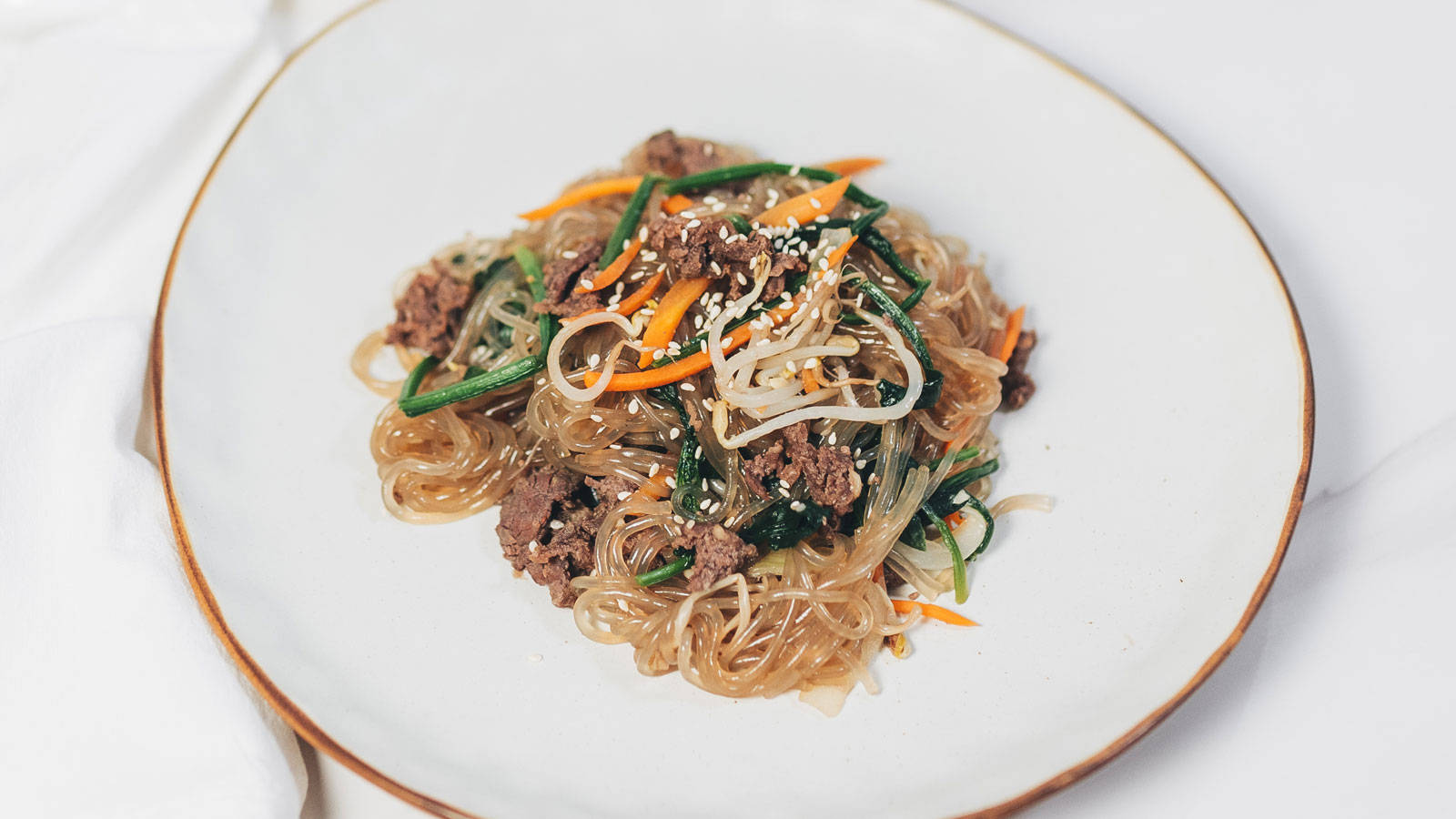 Caption: Savory Bulgogi Meets Colorful Japchae Background