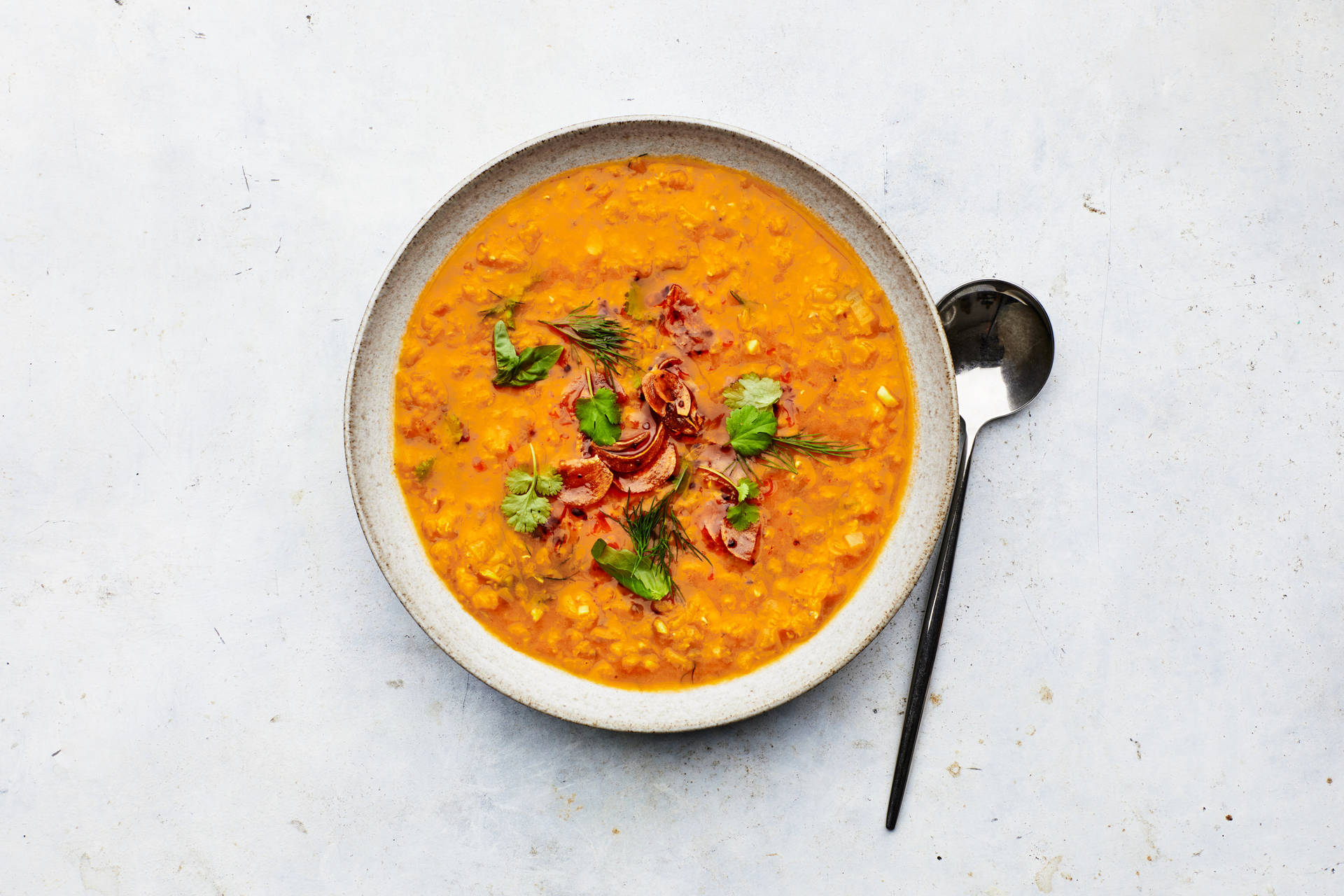 Caption: Savory Red Lentil Soup Garnished With Spice Background