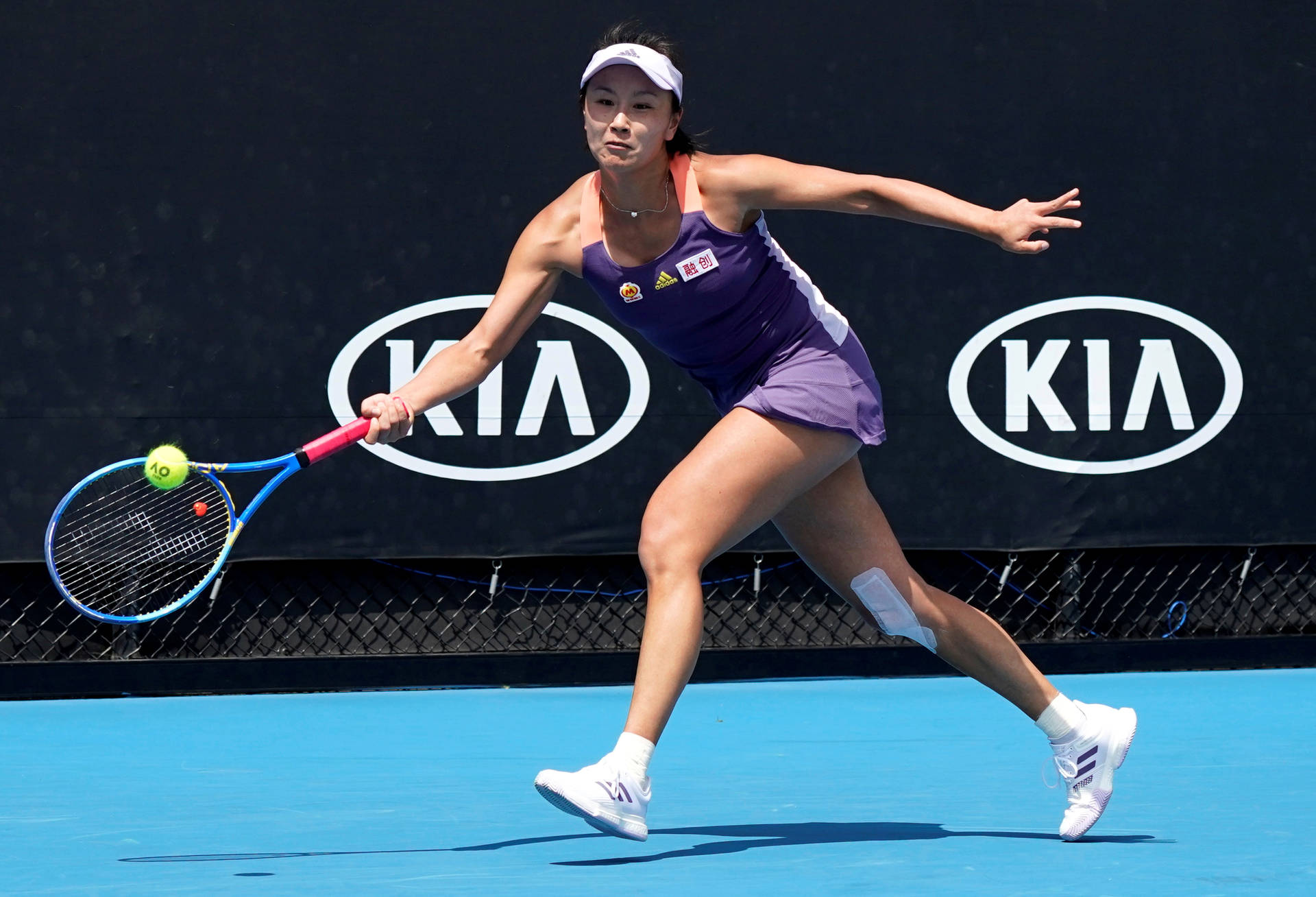 Caption: Shuai Peng In-action At The Blue Tennis Court. Background