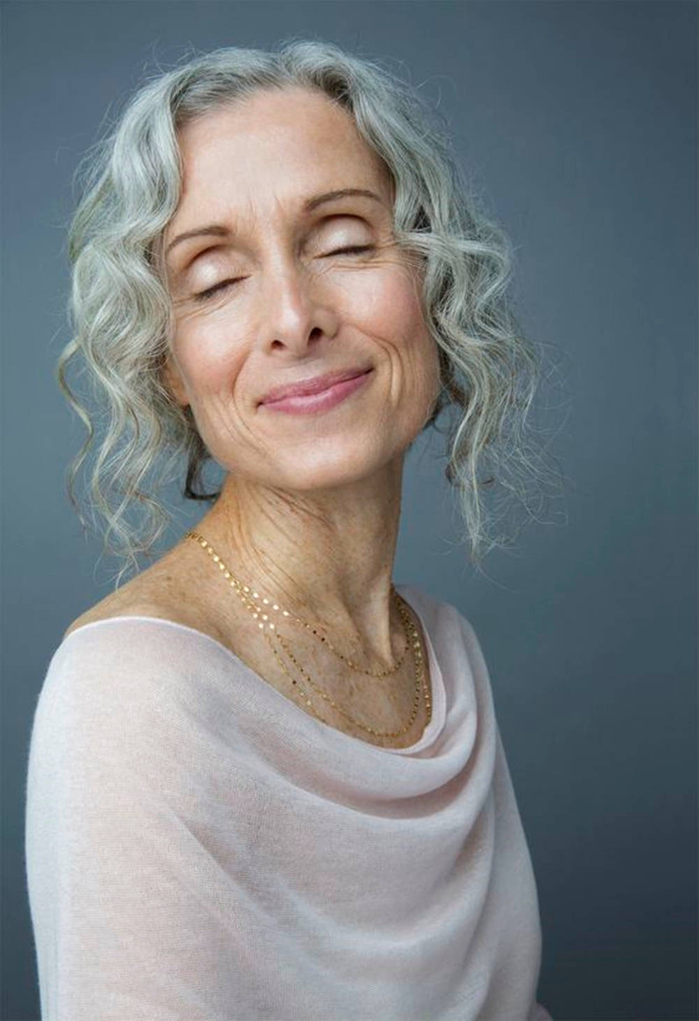 Caption: Spirited Senior Woman With Voluminous Curly Hair Background