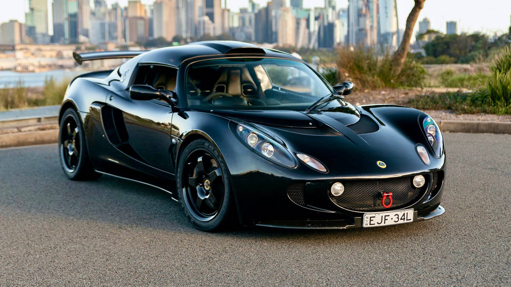 Caption: Striking Black Lotus Exige Dominating The Road Background