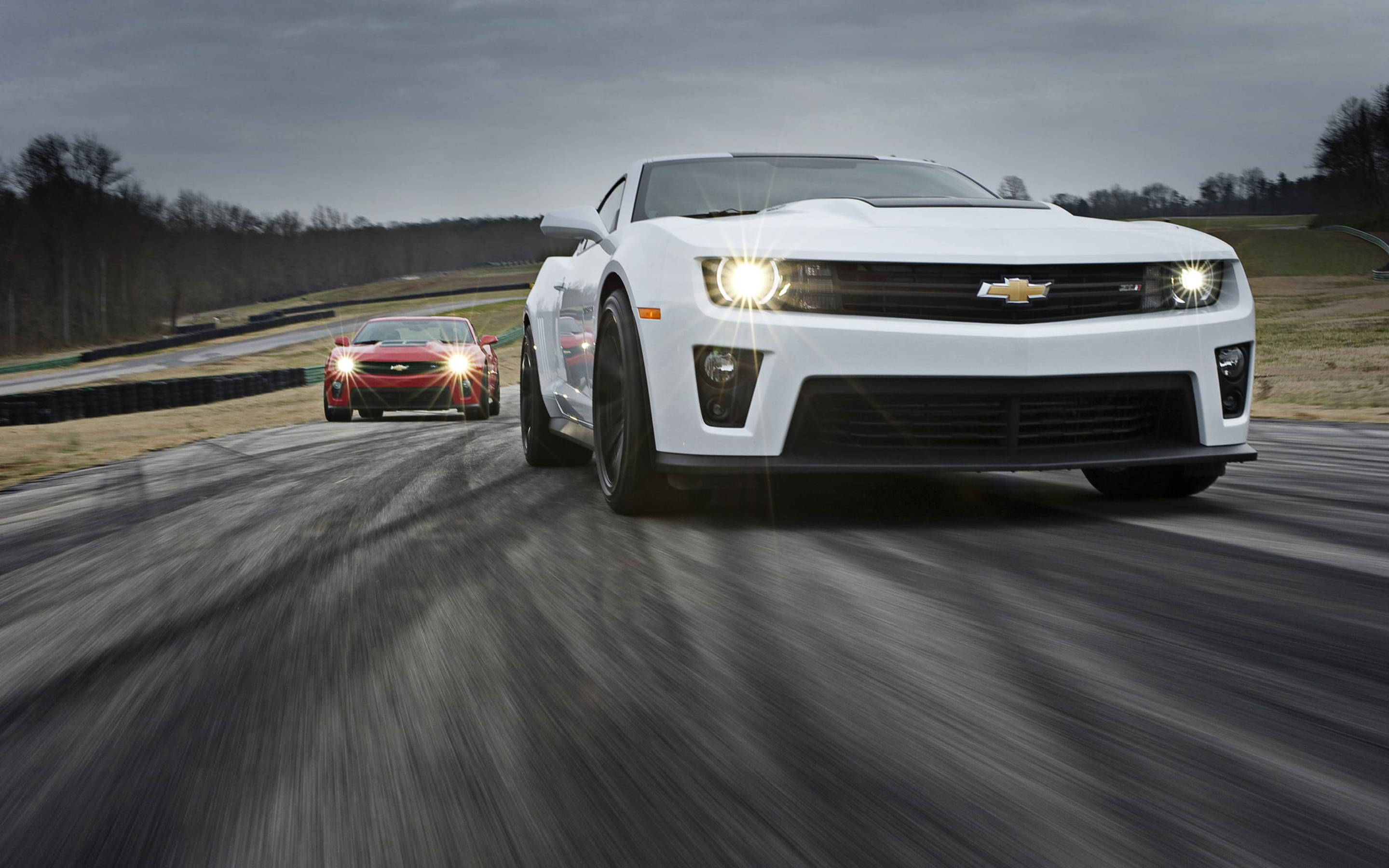 Caption: Striking Speed - A Chevrolet Camaro Muscle Car In Its Racing Glory Background