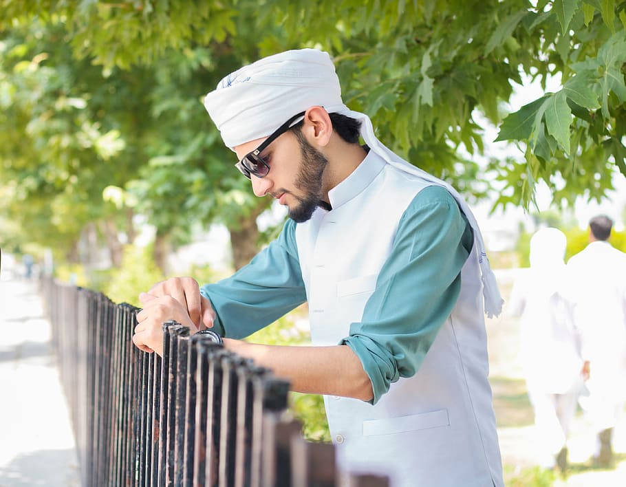 Caption: Stylish Islamic Boy Posing For A Photoshoot Background