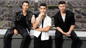 Caption: The Iconic Jonas Brothers At Music Event Background