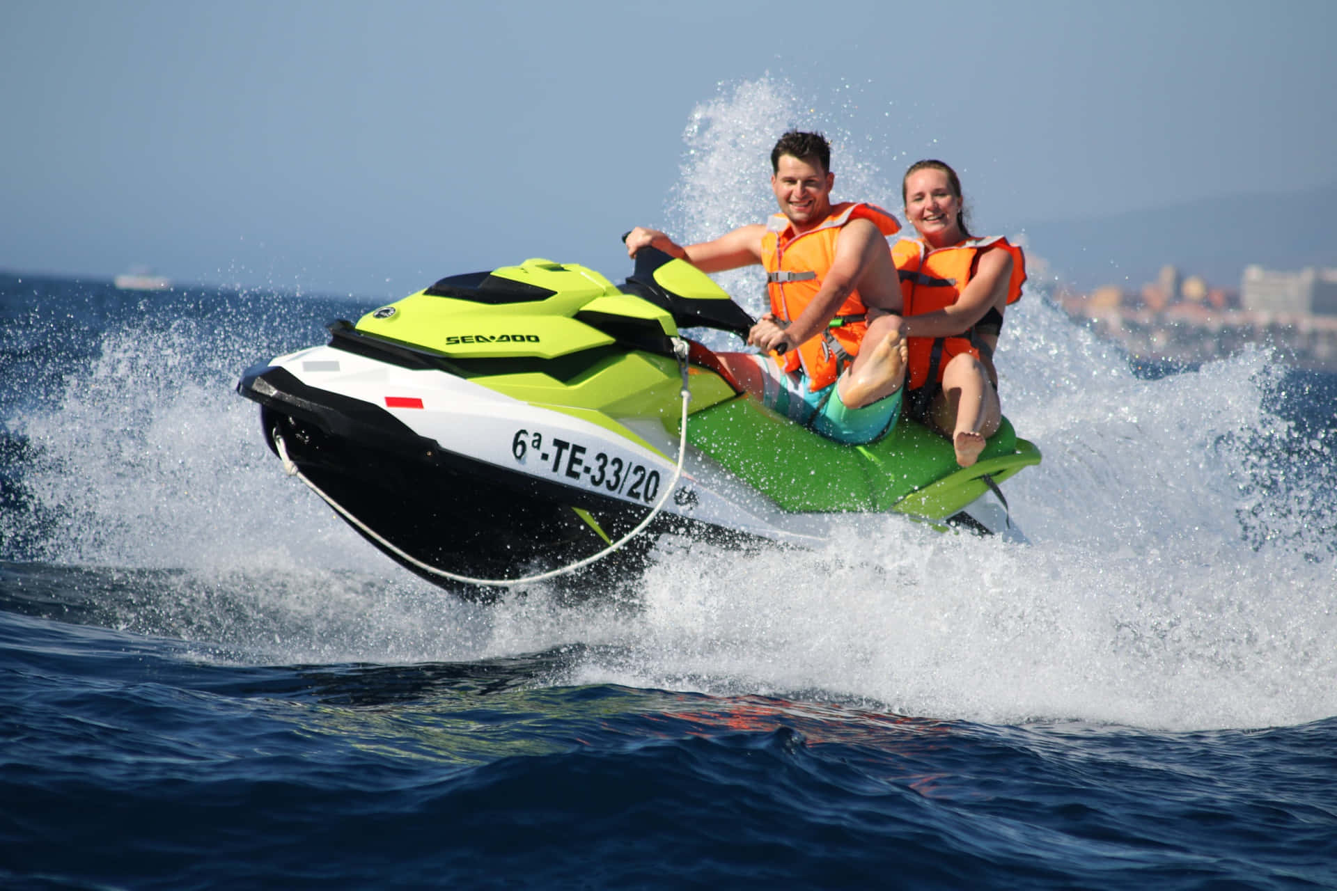 Caption: Thrill-seeking Couple Accelerating Their Jet Ski On Crystal Clear Waters