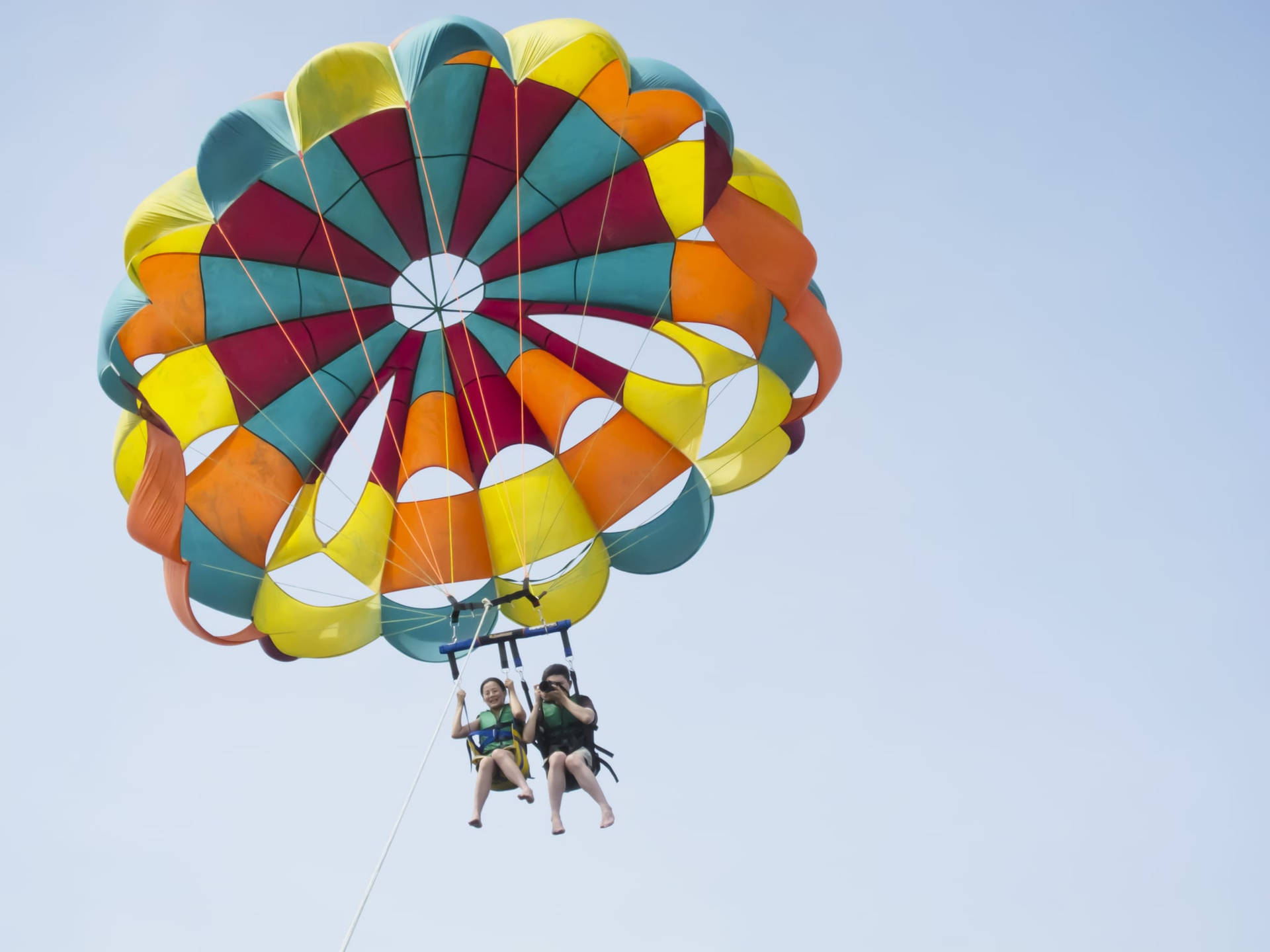 Caption: Thrilling Adventure Of Parasailing In The Middle East Background