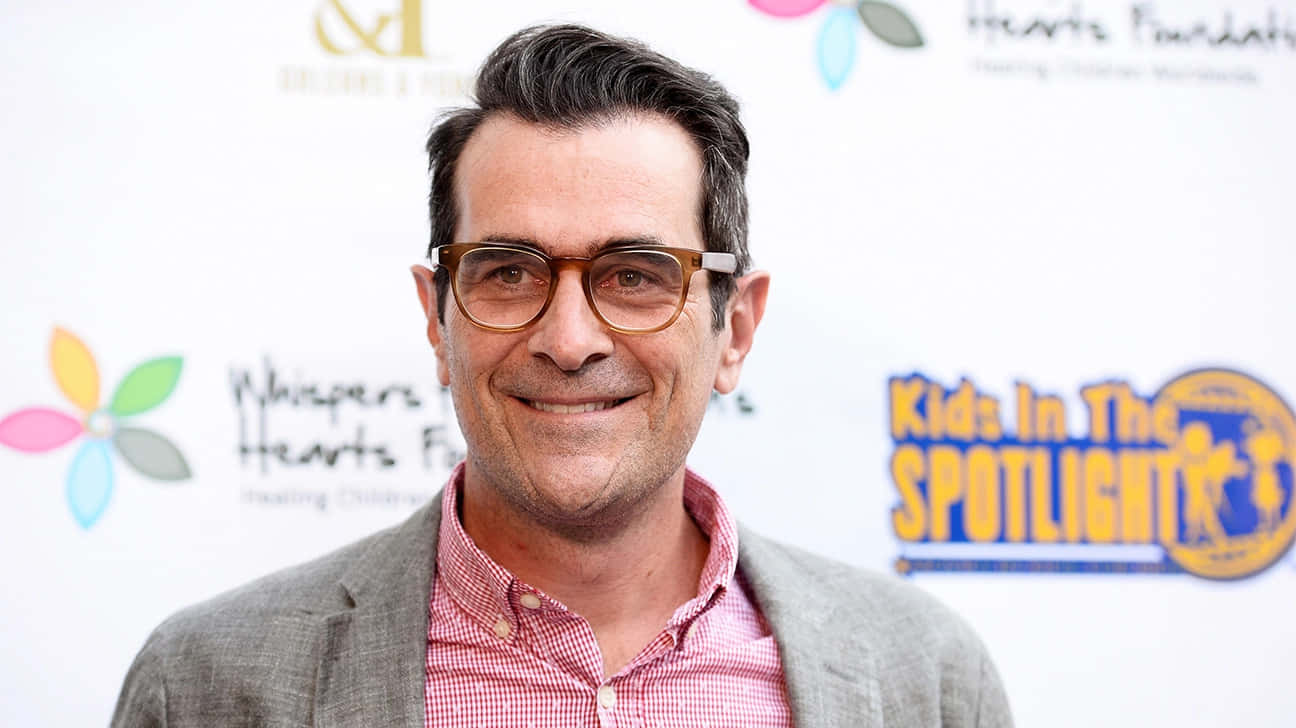 Caption: Ty Burrell Smiling During An Interview Background