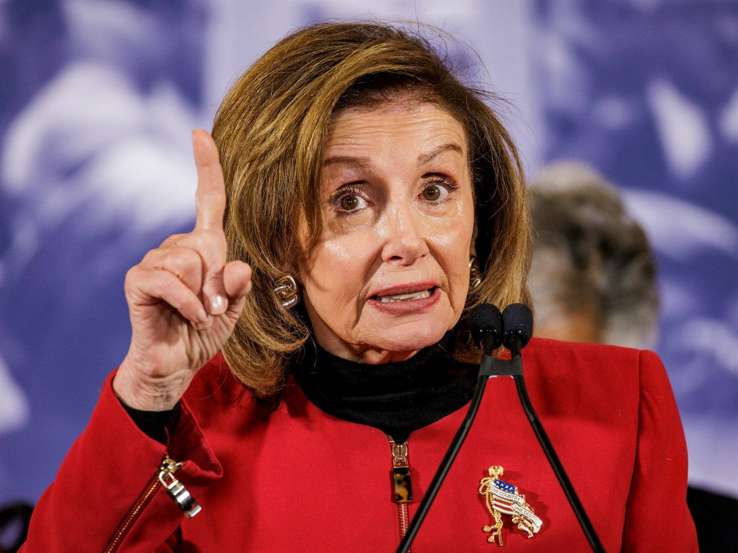 Caption: U.s. Speaker Of The House, Nancy Pelosi, Gesturing Upward During A Public Event