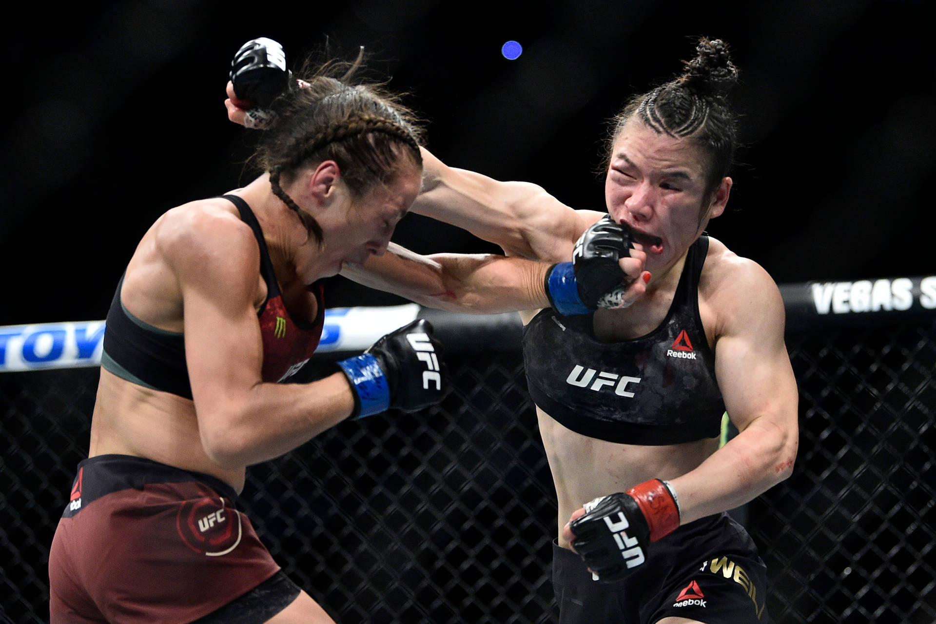 Caption: Ufc Fighters Zhang Weili And Joanna Jedrzejczyk In Intensive Combat Background