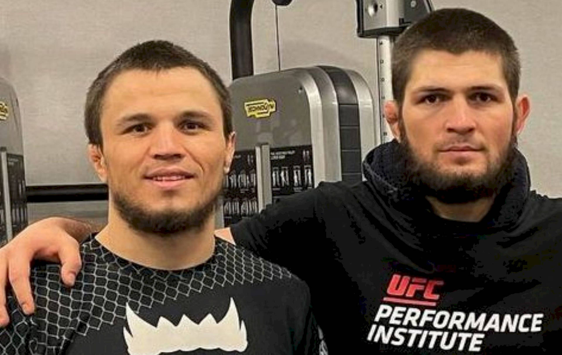 Caption: Umar Nurmagomedov And Khabib Nurmagomedov Engrossed In Gym Training Session Background