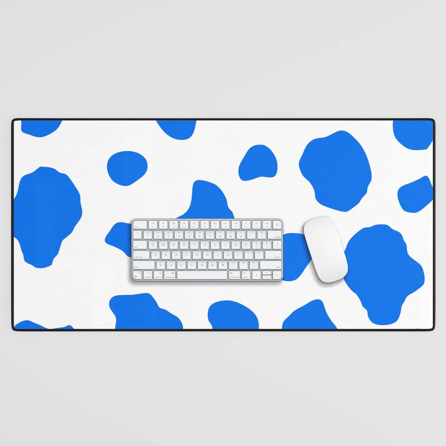 Caption: Vibrant Blue Cow Print On Desk Mat And Keyboard Background