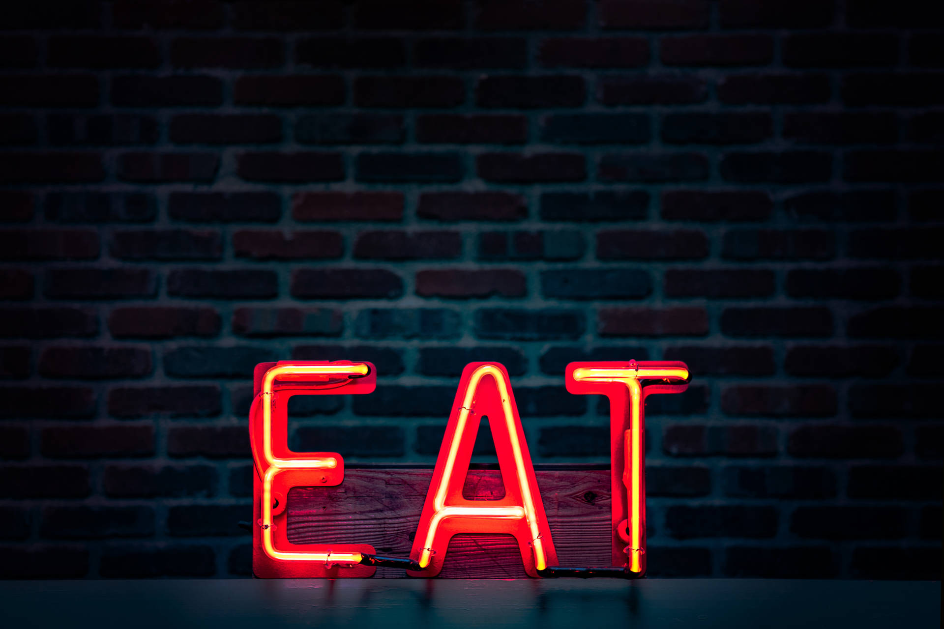 Caption: Vibrant Neon Sign Encouraging To 'eat' Background