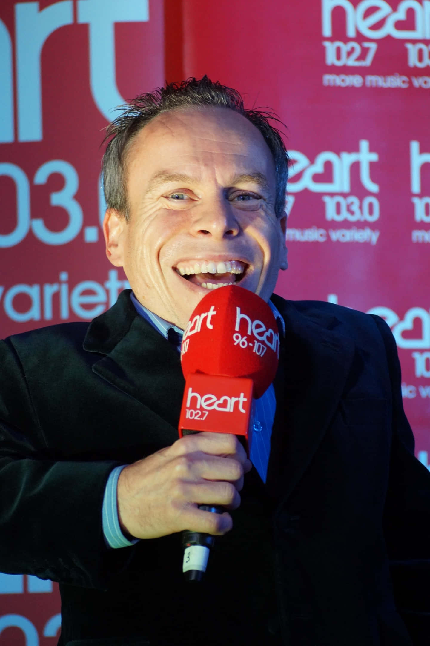 Caption: Warwick Davis Posing At An Event Background
