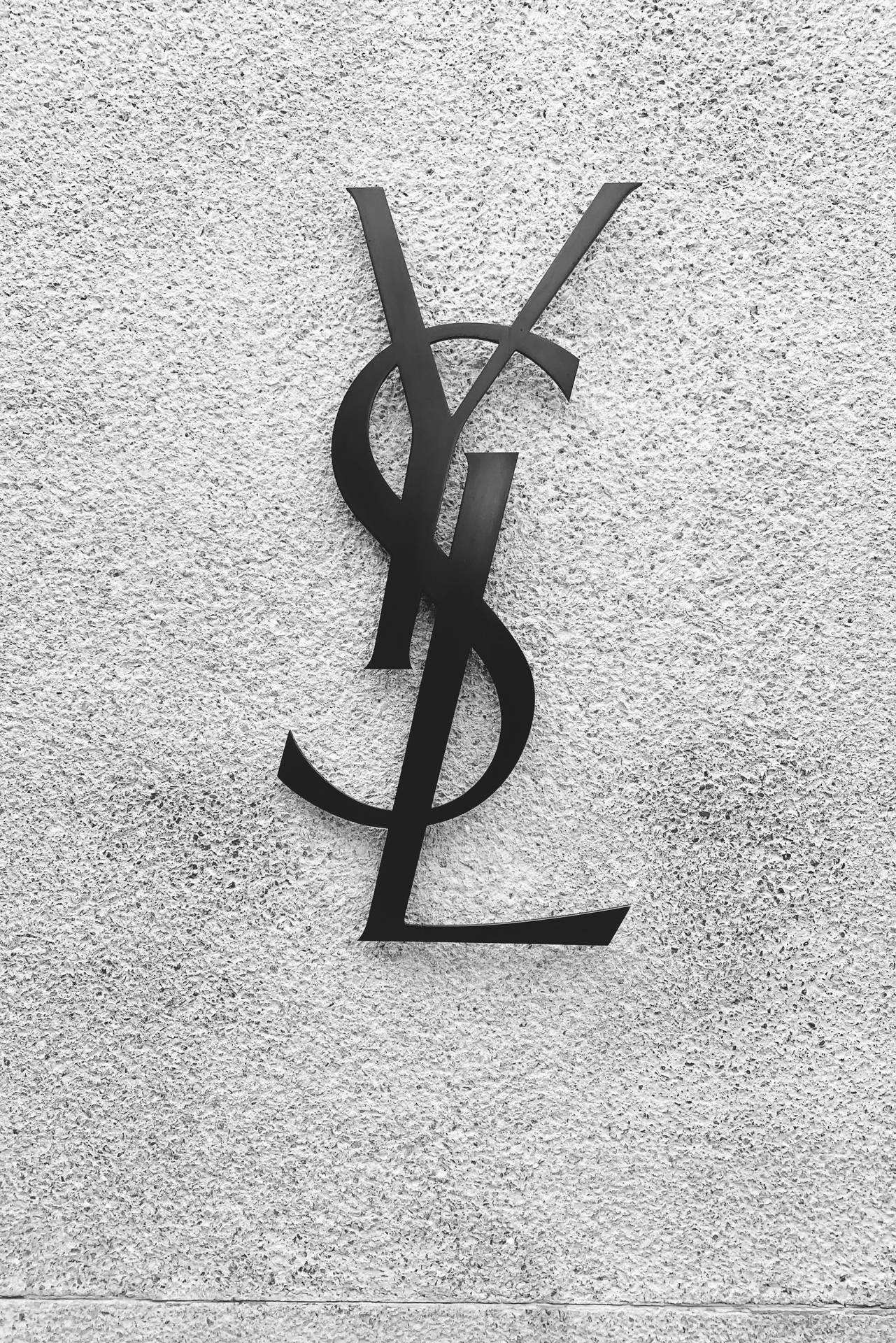 Caption: Ysl Logo Against A Black Concrete Wall Background