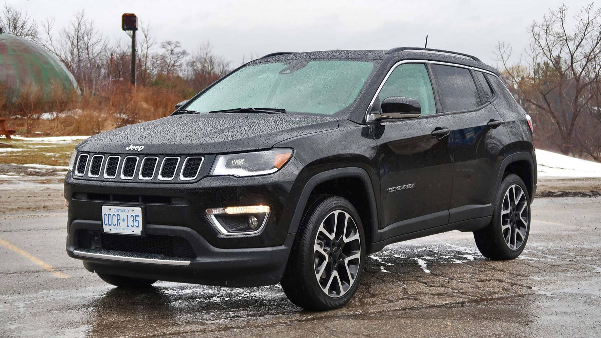 Captivating Black Jeep Compass On A Wet Road Background