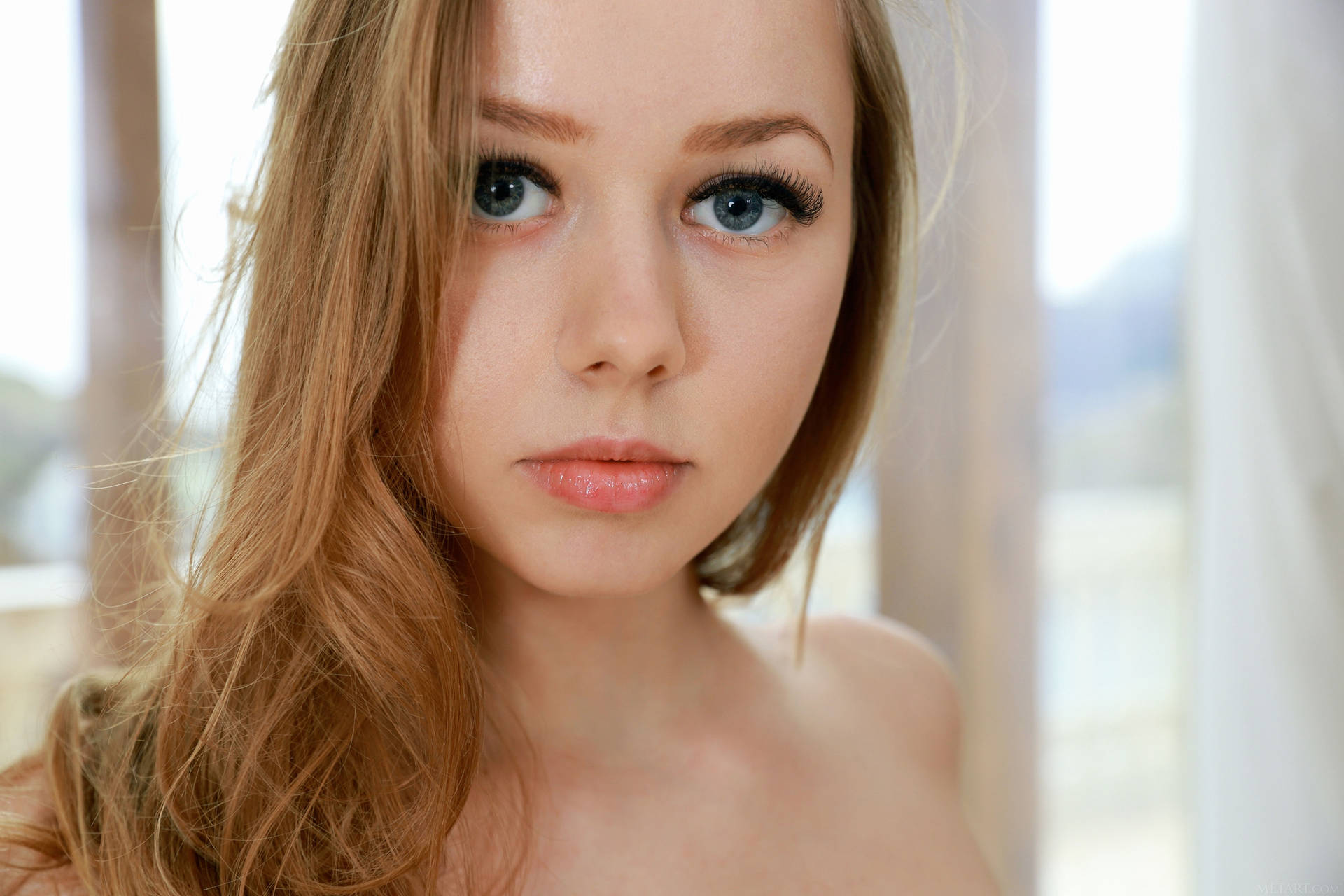 Captivating Gaze Of A Blonde Female Model Background