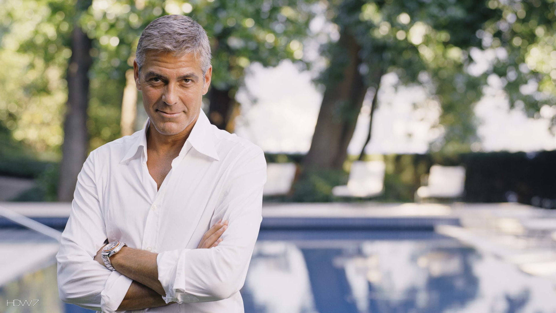 Captivating George Clooney With His Arms Crossed Background