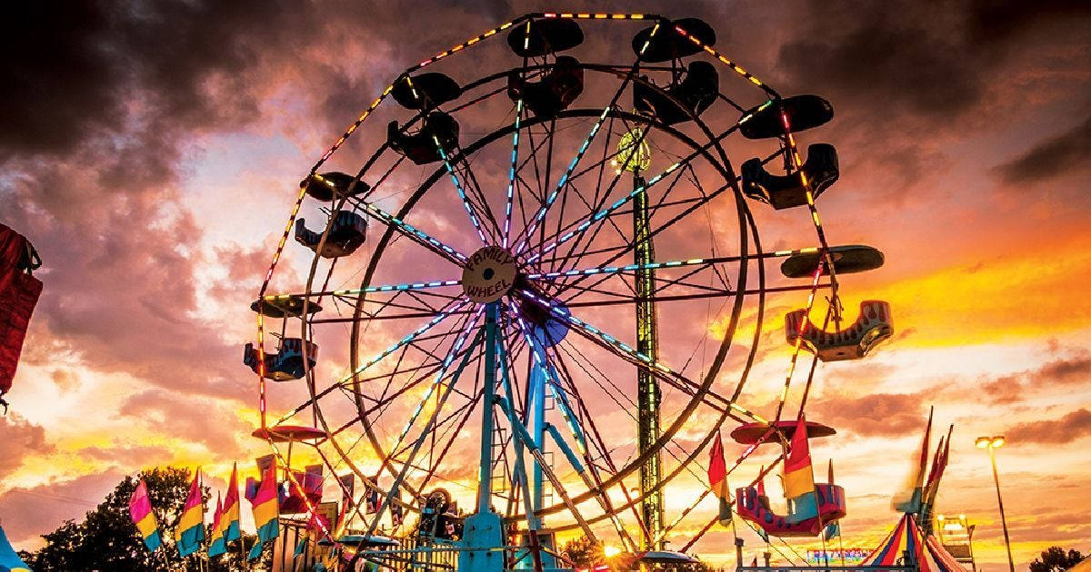 Captivating Orange Sky Above A Vibrant Fair Background