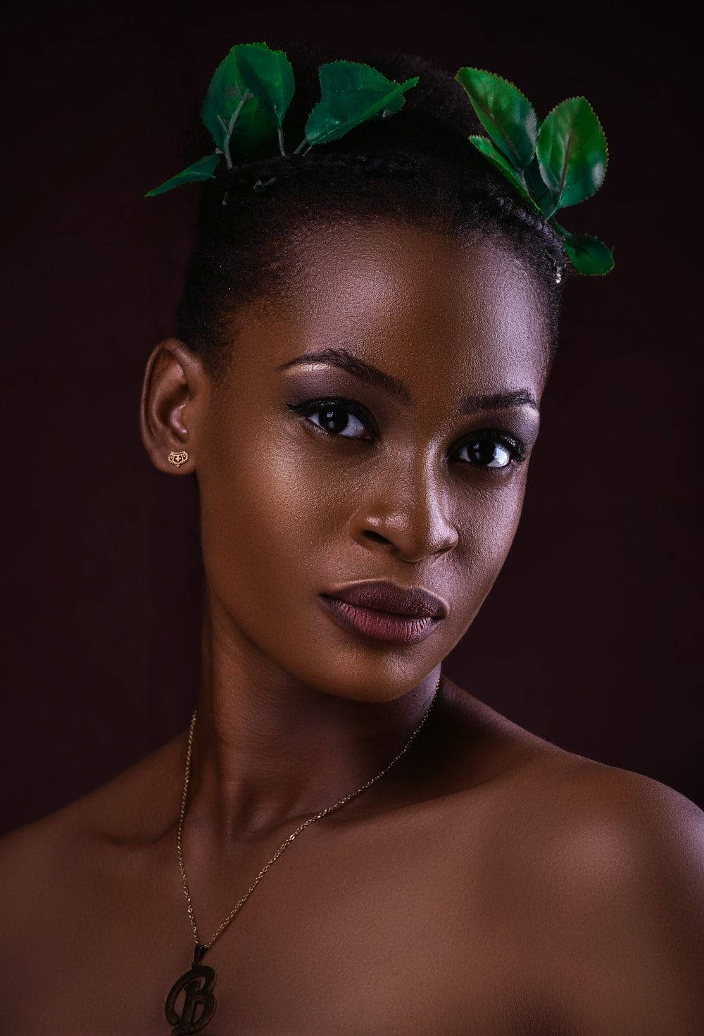 Captivating Portrait Of Beautiful Black Woman In Leaf Headdress Background