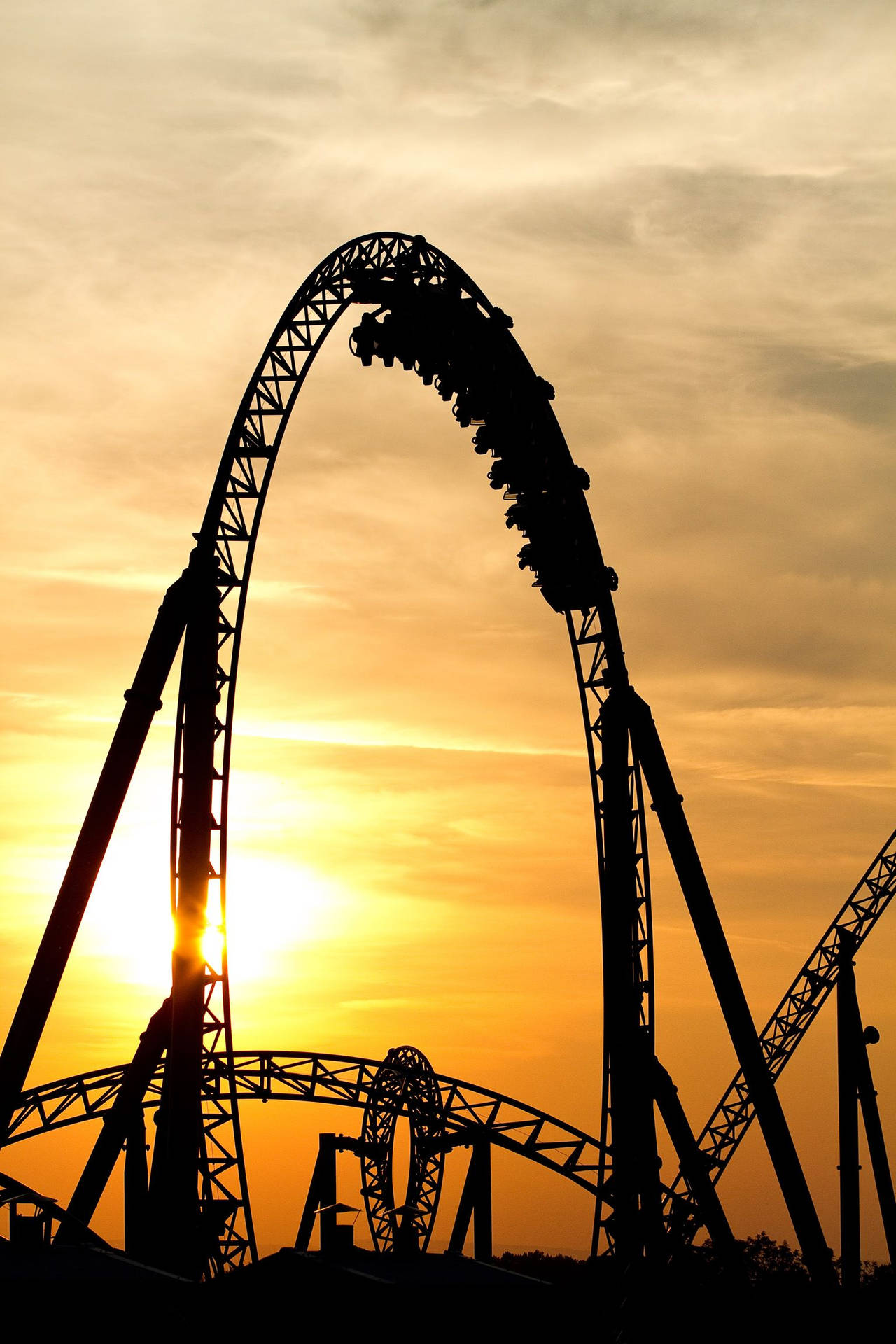 Captivating Silhouette Of Arching Roller Coaster Background