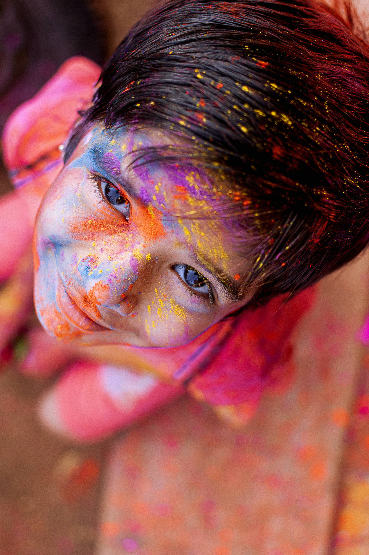 Capturing The Spirit Of Holi - Child Joyfully Covered In Holi Colours Background