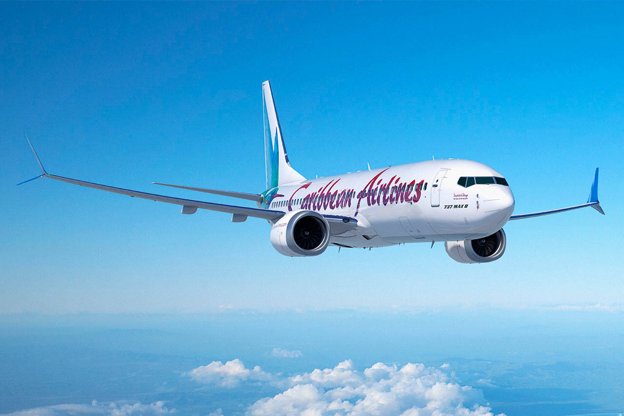 Caribbean Airlines Airplane In The Bright Blue Sky Background