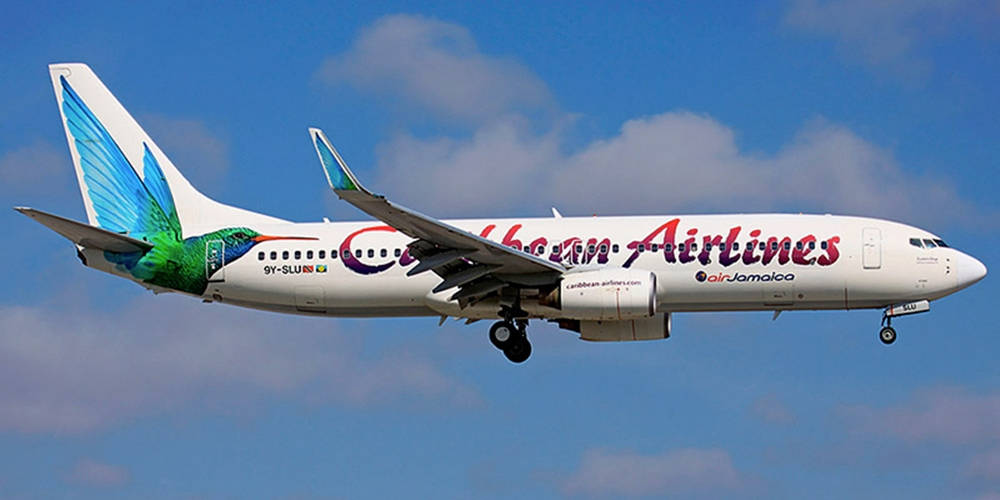 Caribbean Airlines Flying In The Blue Sky Background