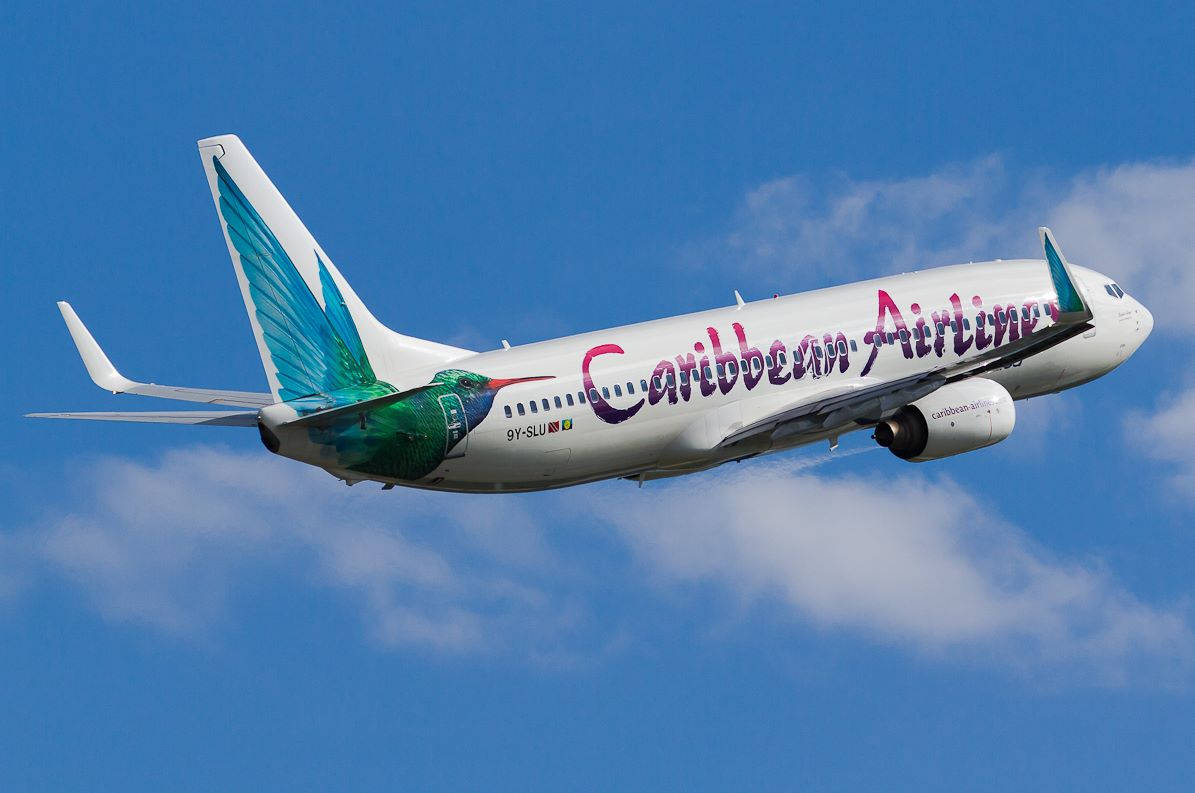 Caribbean Airlines Flying In The Sky Background