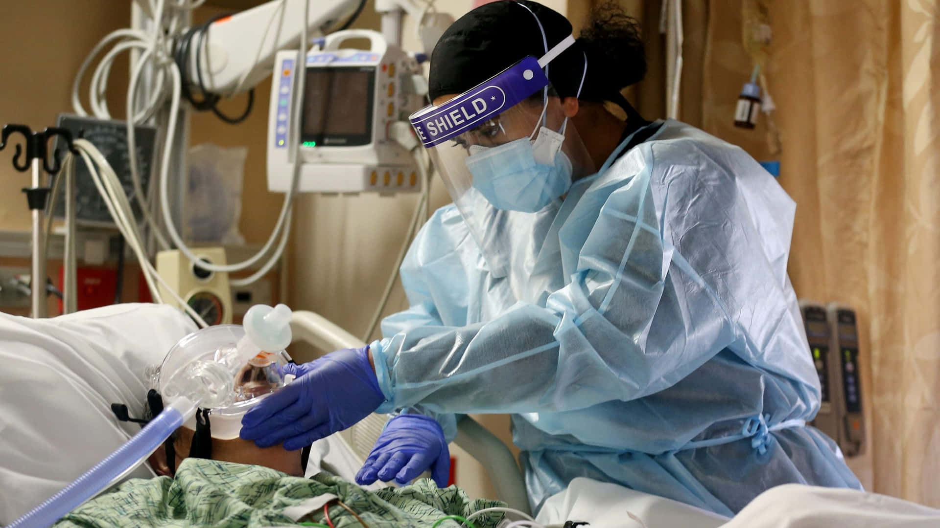 Caring Nurse Assisting Patient On Hospital Bed