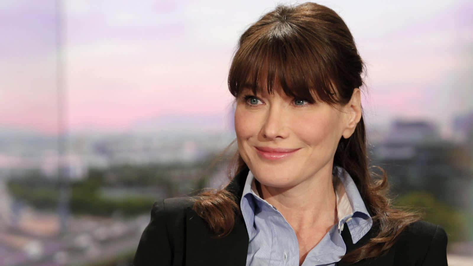 Carla Bruni Elegantly Leaning At The Piano In A Candid Moment Background