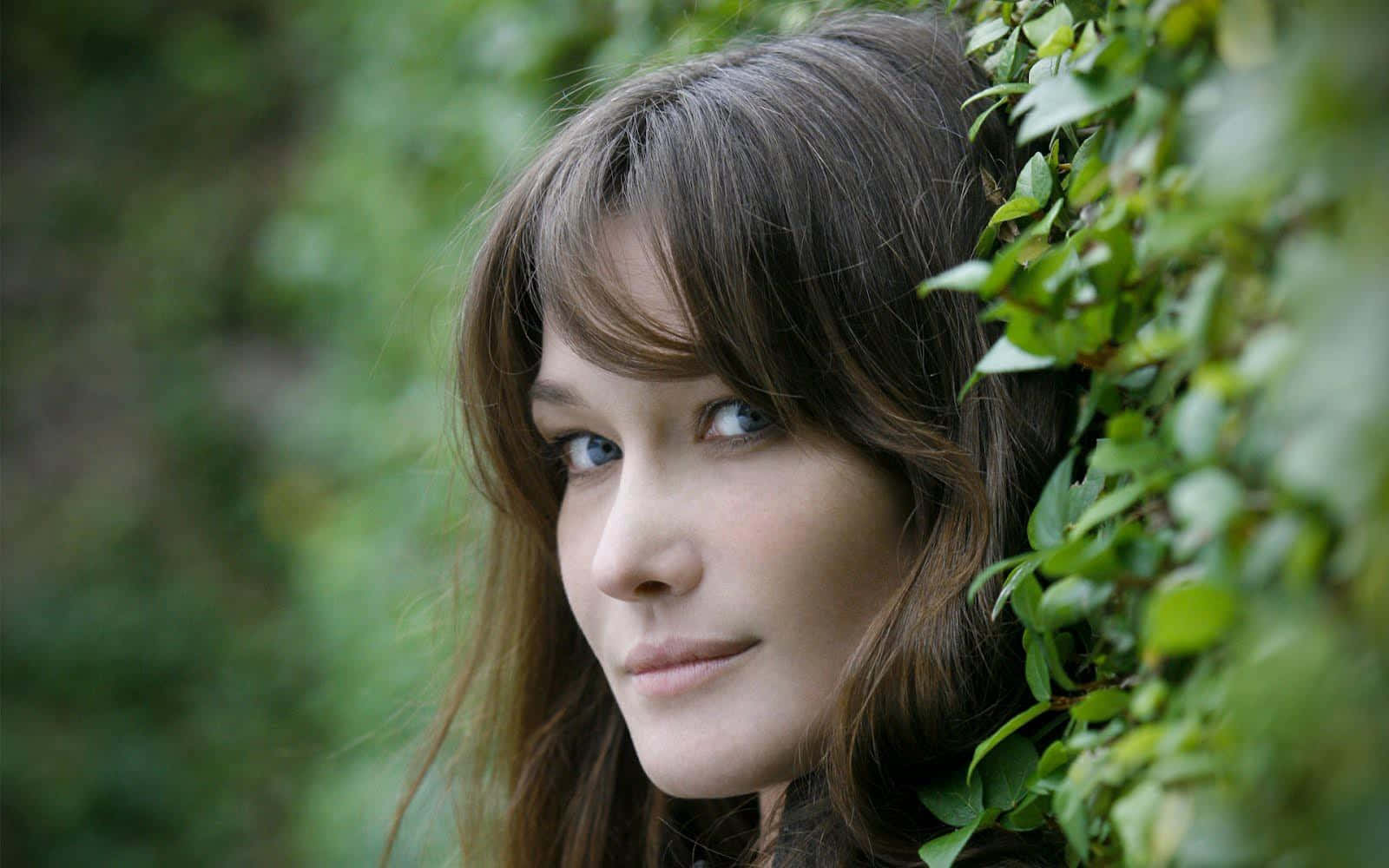 Carla Bruni Striking A Pose In An Elegant Black Dress Background