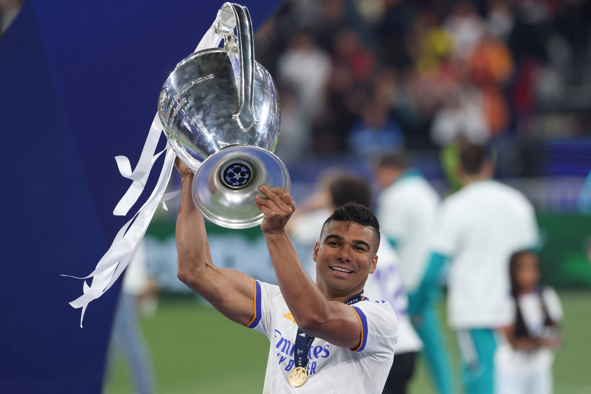 Carlos Casimiro Holds Up Trophy Background