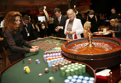 Casino Dealer Conducting A Roulette Background