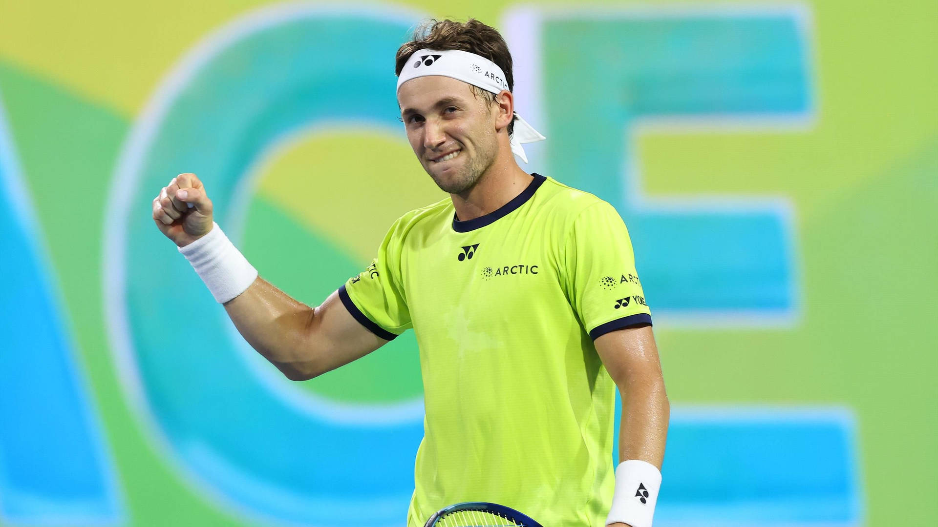 Casper Ruud Smiling In Yellow Shirt Background