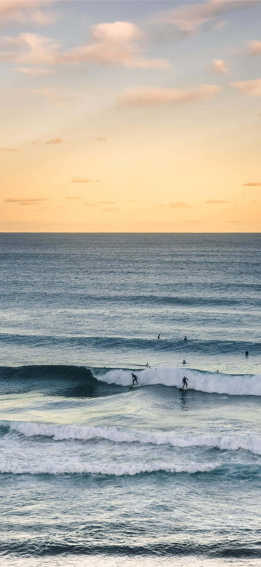 Catch The Wave - A Surfer Riding A Wave In The Ocean While Using Their Iphone Background