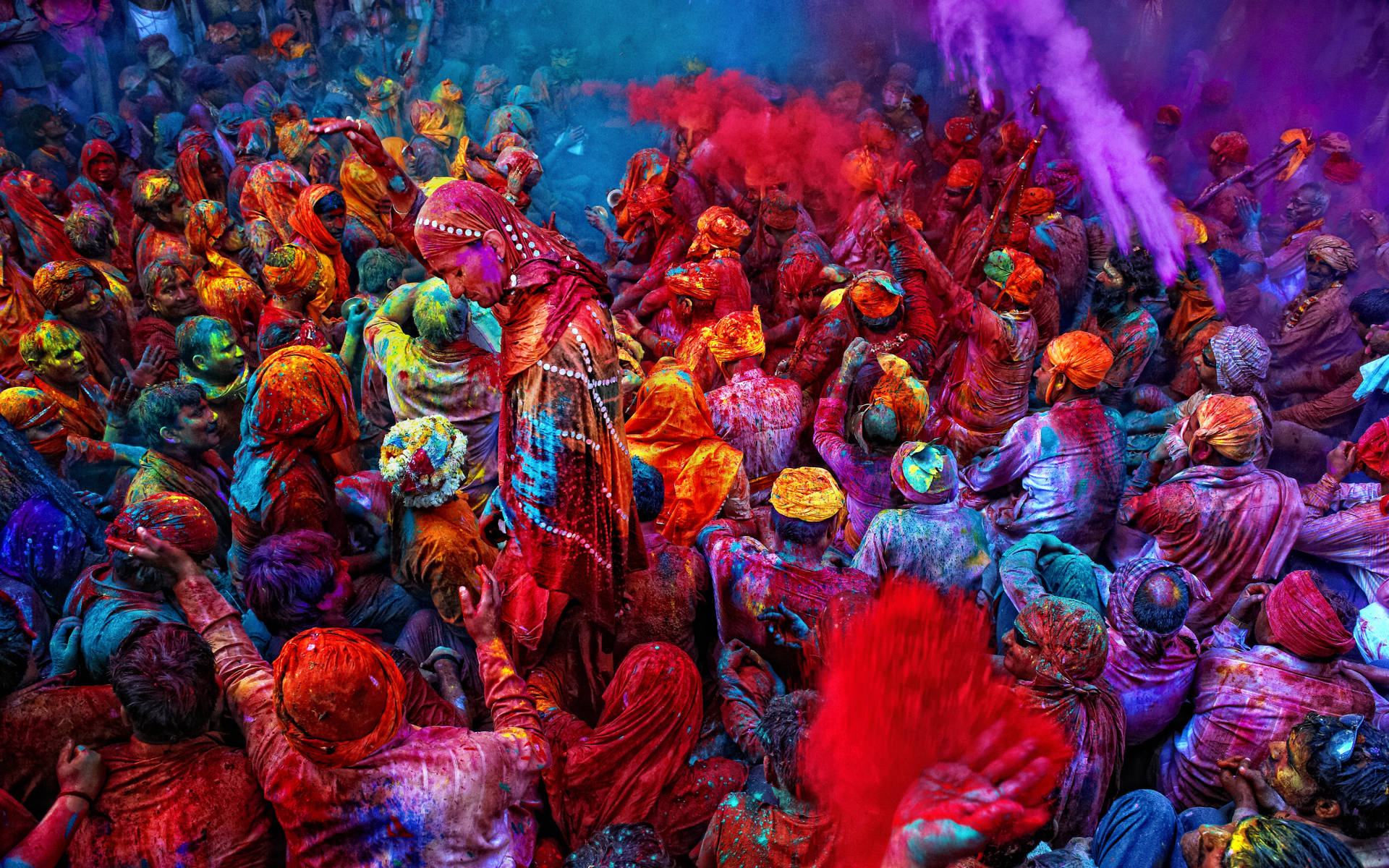 Celebrate Vibrancy And Joy With This Happy Holi Hd Image Depicting A Colorful Crowd. Background